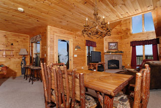 Pigeon Forge Cabin that has a dinning area that overlooks the gameroom kitchen and living room area